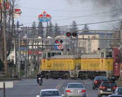 The line turns and crosses 1st Ave as it starts its climb out of the river valley. Contrary to what it looks like, the motorcycle did NOT just cut around the train.