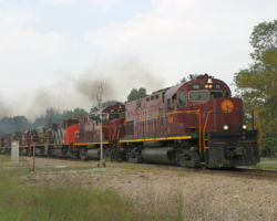 Once over the grade, this crew is wasting no time getting home. Here they are thundering through Butterfield under cloudy skies
