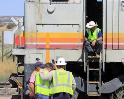 Having completed loading of the Sunday morning train, a number of employees gather to appreciate of the moment before the train heads back to Page.