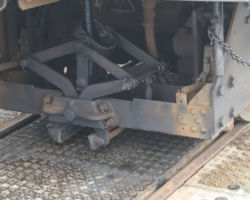 At the other end of the truck from the guide wheels is a screw-driven clamp with brake shoes.  When applied, these shoes grip the sides of the Fell rail and slow the car (or prevent it from moving at all)