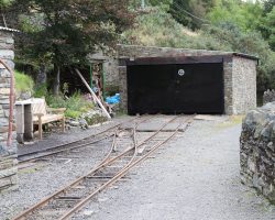 At the east end is another small shed. The right wall is where the original ore chutes would have been located, and ore cars would have been dumped over the edge.