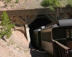 Just after Phantom Curve comes Mud Tunnel. It gets its name from the soft volcanic ash and mud that it's bored through. Because of the instability of the material, this tunnel is lined with wood and concrete to prevent collapse. Here you're looking at the west portal as the train dives inside.