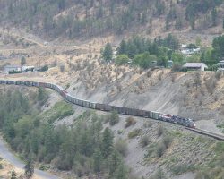 The northbound SQPG crawls along the hillside, leaving the town of Lillooet as seen from across the river.