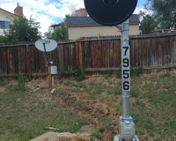 Trenching between the signal and the satellite pole for the ground wire and signal cable.