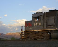 SP 9733 and UP 5338 depart Grand Junction for Delta, CO, in the warm morning light.