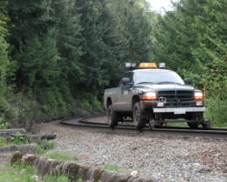 A pilot vehicle rounds the bend at Lions Bay.
