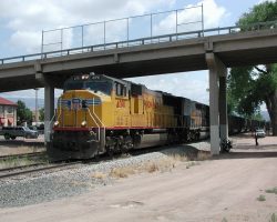 Finally fully occupying the station platform area, UP4091 pulls under the bridge and west.