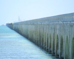 The Seven Mile Bridge, as seen from the south end of the structure. It starts out as another arch bridge, and then ramps up to a deck girder about 1.7 miles out. The structures barely visible to the left of the bridge are on Pigeon Key, a tiny island about halfway across the span (and where the bridge turns to the east/right).