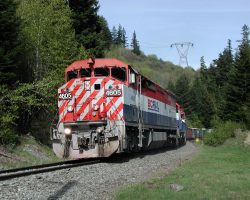 A few miles back down the line, 4605 and train snake out of the forest again to cross the main highway.