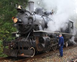 While the pump moves water from the tank into 25's tender, the crew takes the opportunity to do a little oiling in the pouring rain