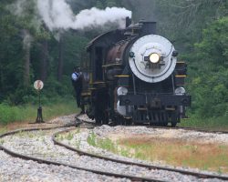 Bright and early Saturday morning, #300 comes around the curve from the shops into the Rusk station to couple on to the train.