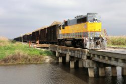 USSC 405 approaches a grade crossing outside of Bryant yard with a cane load. This will be combined with other loads at Bryant and run back to Clewiston on the SCXF mainline.