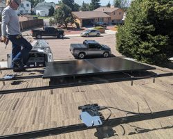 With the microinverters installed, the first panels go down on the racks over the garage