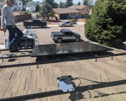 With the microinverters installed, the first panels go down on the racks over the garage